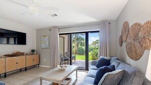 Una sala de estar moderna con un sofá, una mesa de centro y un televisor de pantalla plana montado en la pared.