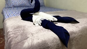 A bed with a blue and white checkered bedspread and a dark blue blanket.