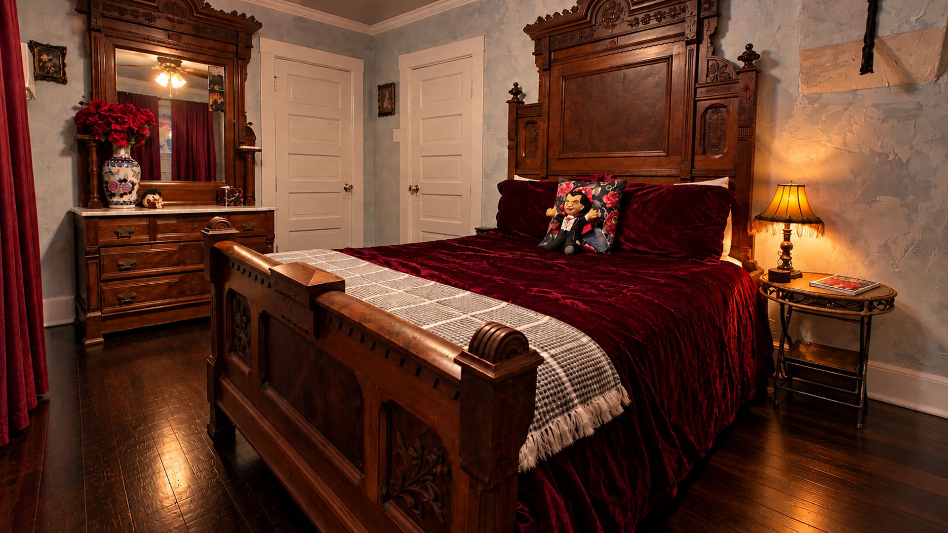 Une chambre à coucher de style traditionnel, avec un lit en bois, une commode, un miroir et une table de chevet avec une lampe.