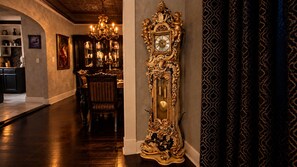 Un'ampia sala da pranzo con un orologio decorativo, un lampadario e un'area dedicata alla ristorazione con tavolo e sedie.