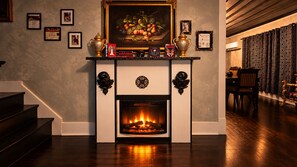 A fireplace with a mantel decorated with books, a framed painting, and trophies. - The vampire's den, downtown big house, pets ok (Fort Smith)