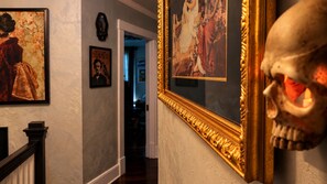 A hallway with framed artwork and a skull decoration. - The vampire's den, downtown big house, pets ok (Fort Smith)