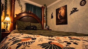 Una camera da letto con un letto grande, un comodino, una lampada, un quadro appeso al muro e uno specchio decorativo.