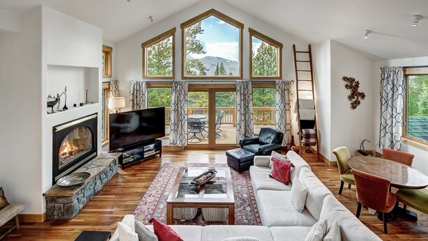 A spacious living room with a fireplace, a large TV, and a cozy seating area.
