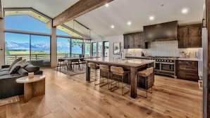 Una cocina amplia con una isla grande, piso de madera y vistas a las montañas.