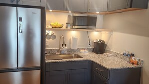 Una cocina moderna con un refrigerador de acero inoxidable, un microondas y una cafetera.