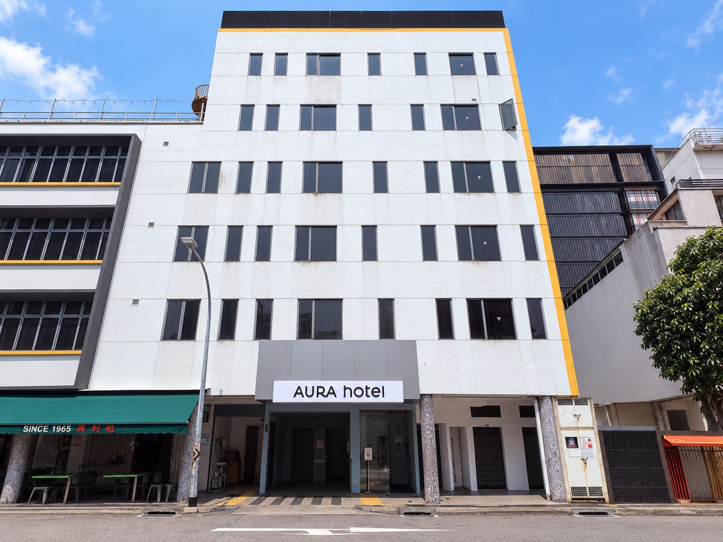 Un hotel de varios pisos con un letrero que dice 'AURA hotel'.