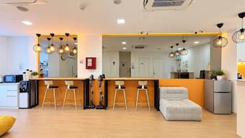 Un interior moderno con zona de bar, asientos y kitchenette.