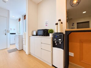 Une cuisine moderne équipée d’un four à micro-ondes, d’un grille-pain et d’un distributeur d’eau.