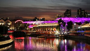 A waterfront hotel with a distinctive roof structure and a river view. - Aura Hotel Mackenzie (Singapore)