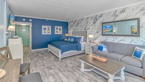 Una camera da letto con un letto, comodini, un divano, un tavolino da caffè e una TV.