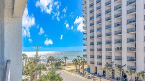 Un hotel moderno con numerosi balconi, vista sulla spiaggia e cielo sereno.