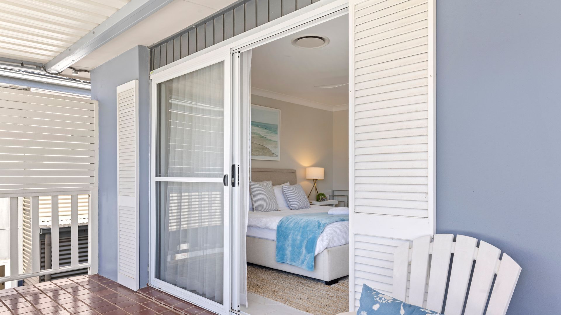 Un dormitorio con cama, mesita de noche y ventana.