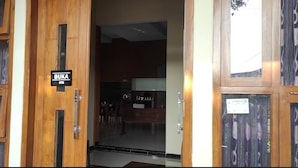 A wooden door with a sign reading "BUKA." - St.ketapang 2 homestay  (Banyuwangi)