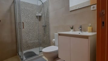 Chuveiro, secador de cabelo, toalhas de banho, papel higiênico