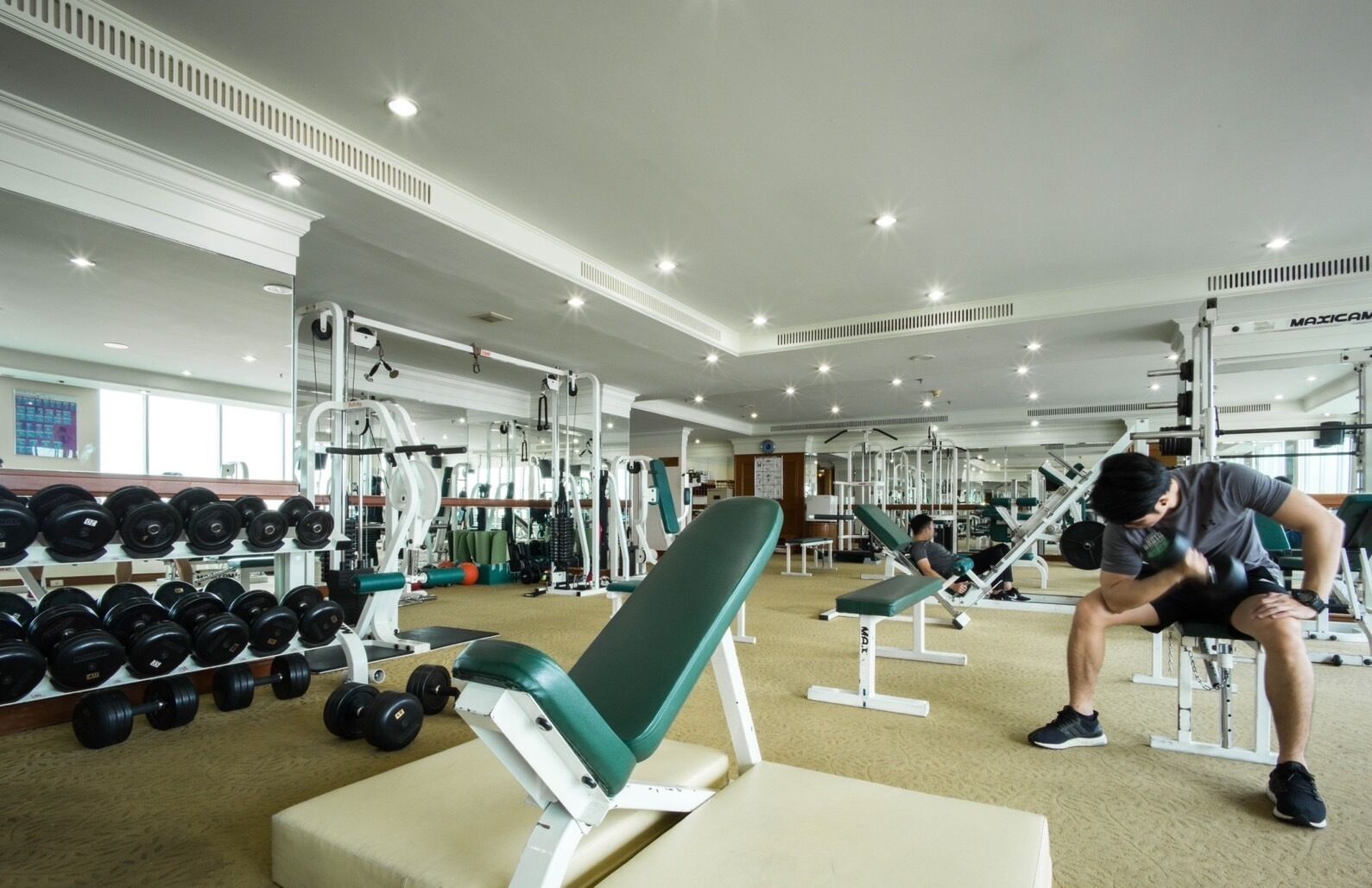 Een fitnessruimte met diverse trainingsapparaten, waaronder gewichten en krachttoestellen.