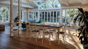 Une salle à manger spacieuse, dotée d’un haut plafond et de grandes fenêtres, qui permettent à la lumière naturelle d’inonder l’espace.