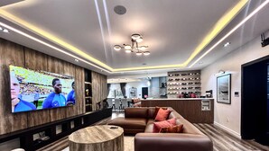 A modern living room with a flat-screen TV, leather sofa, and a wooden coffee table. - Luxury, contemporary 4-Bed Apartment in Ikoyi (Lagos)