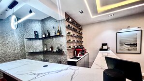 A modern bar area with a marble countertop, shelves with bottles, and a framed picture on the wall. - Luxury, contemporary 4-Bed Apartment in Ikoyi (Lagos)
