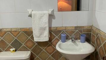 Un baño con inodoro, lavabo y espejo.