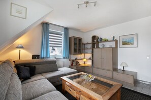 A modern living room with a sofa, a wooden coffee table, and a cabinet.