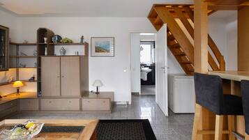 Une cuisine moderne avec des meubles en bois, une table à manger et un escalier menant à un niveau supérieur.