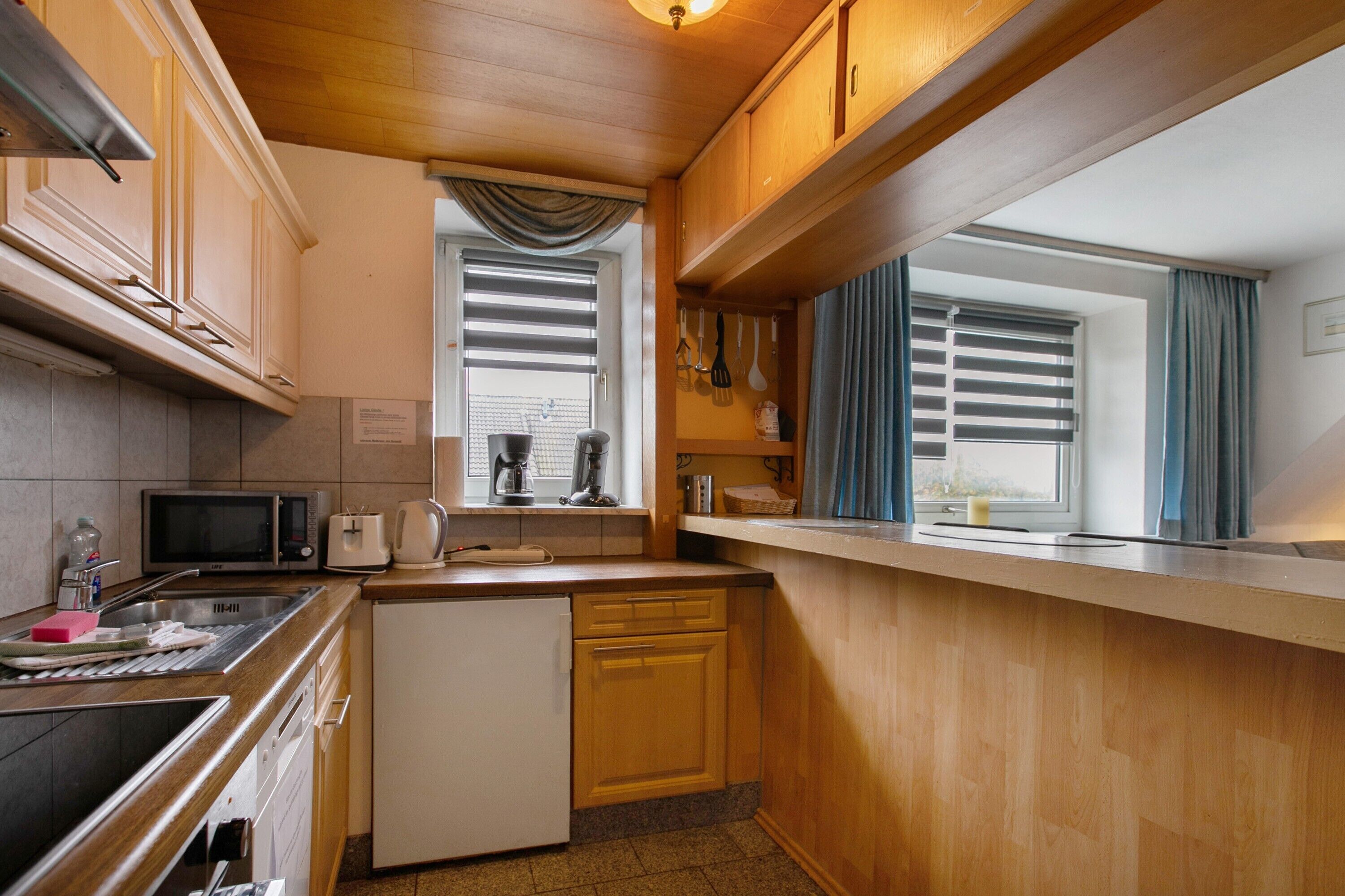A compact kitchen with a microwave, toaster, and sink.