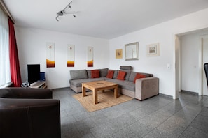 Una sala de estar con un sofá, una mesa de centro y un televisor.