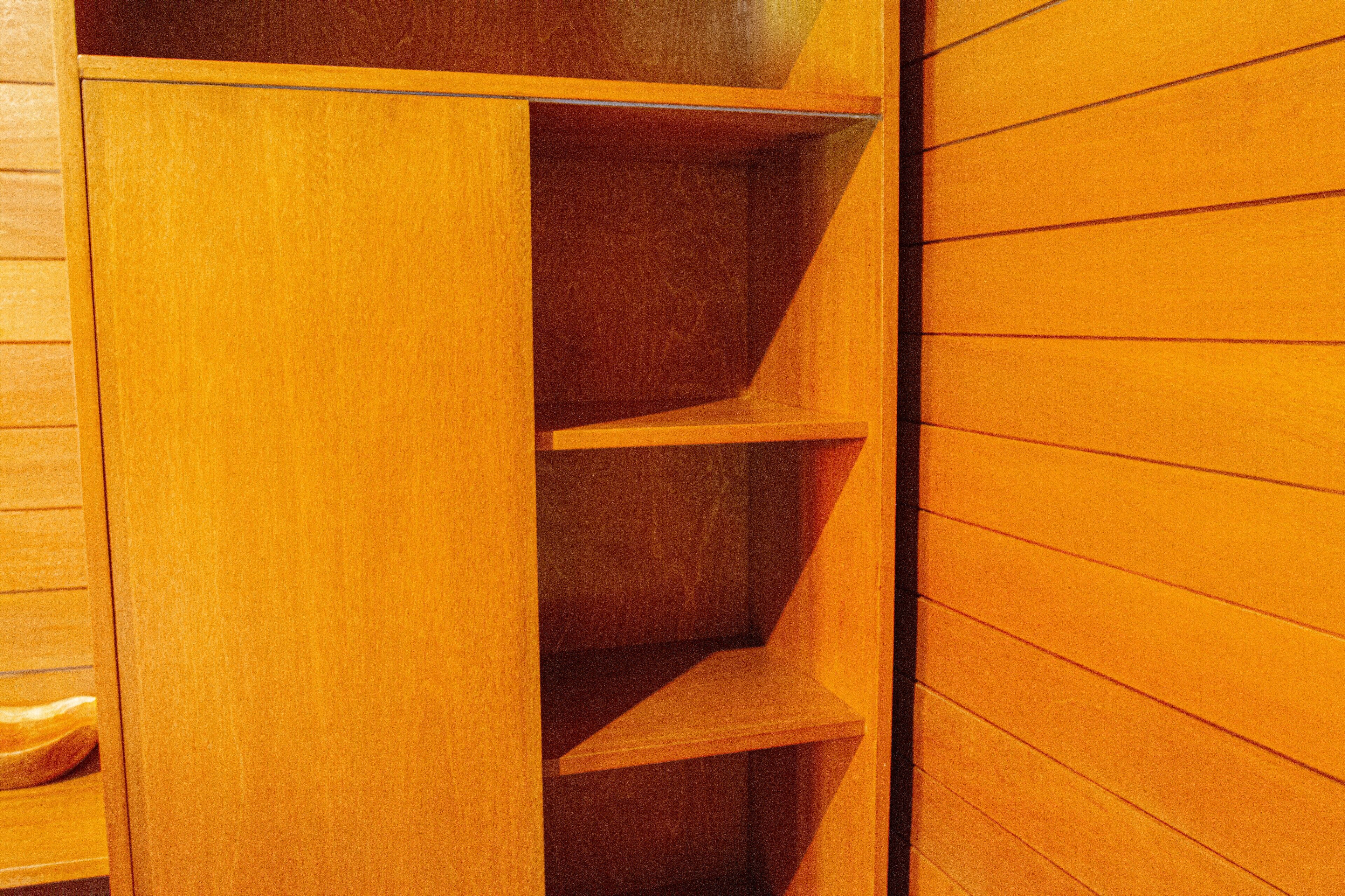 A wooden wardrobe with multiple shelves.