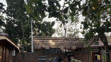 An outdoor seating area with a brick wall, a pergola, and a menu board.