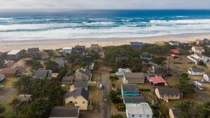 A coastal residential area with houses, a beach, and the ocean.