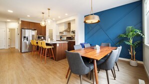 Una cocina moderna con una isla central, una mesa de comedor de madera y sillas.