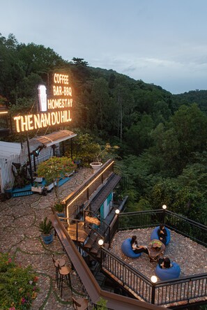 A coffee bar-bq homestay named "The Namduhill" with outdoor seating and a view of the surrounding forest. - The Nam Du Hill (Kien Hai)