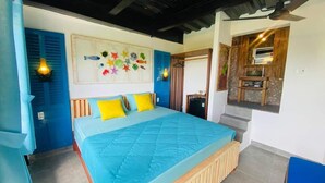 A bedroom with a large bed, a wall-mounted artwork, and a wooden cabinet.