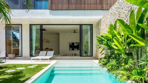 A modern house with a swimming pool, outdoor seating, and lush greenery. - Casa Umalas Villa by Betterplace (Kerobokan)