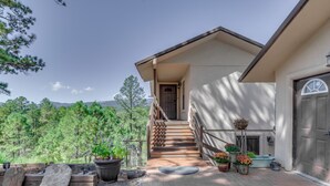 A house with a staircase leading to a door, surrounded by potted plants and a view of trees. - Ruidoso Retreat w/ Sierra Blanca Peak Views! (Ruidoso)
