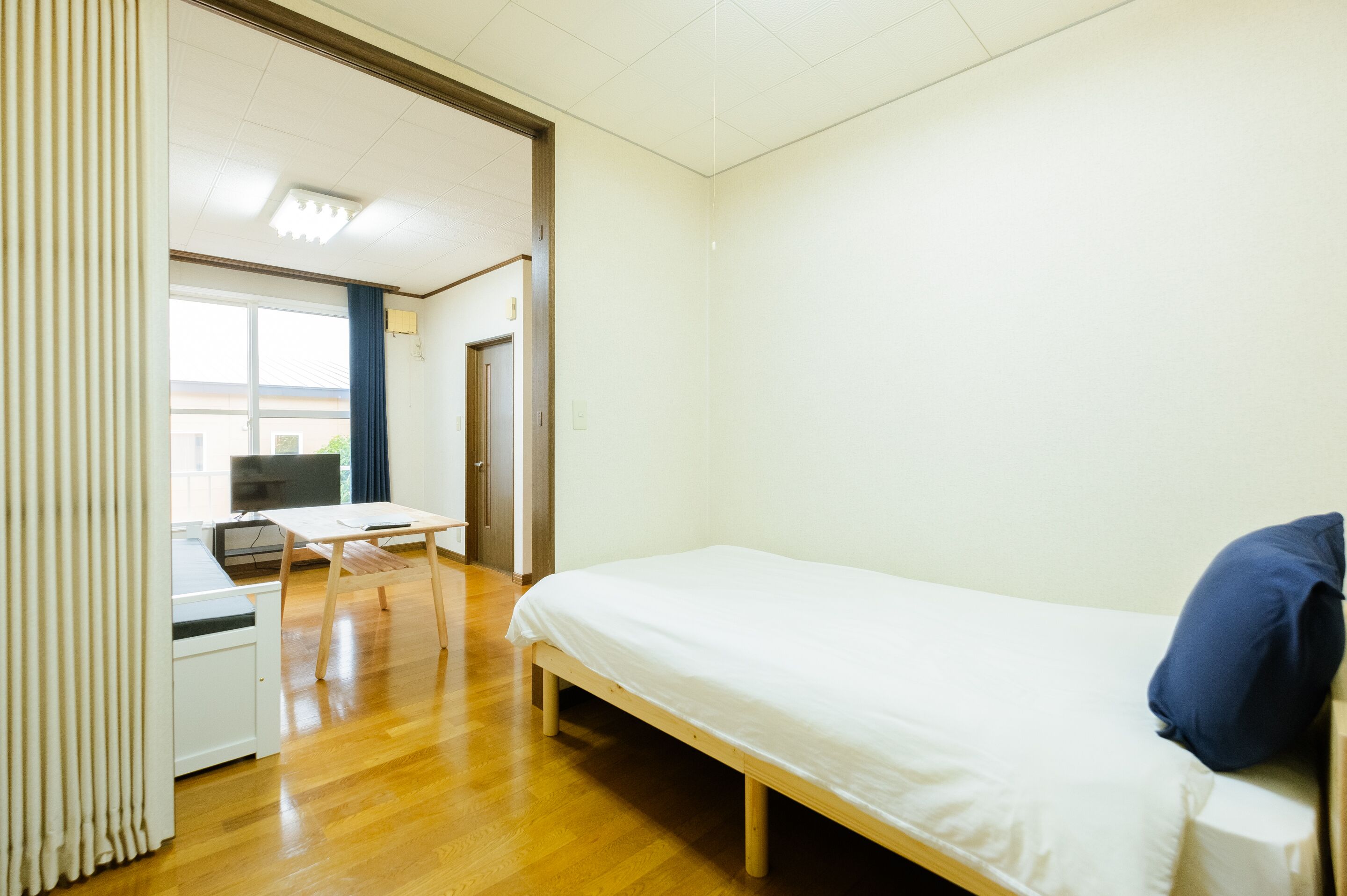 Une chambre avec un lit, un bureau et un téléviseur.