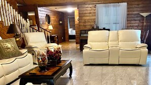 A spacious living room with a wooden ceiling, a white sofa, a beige sofa, a wooden coffee table, and a lamp. - Cozy Country Home 3BR 3BA, 3200 sq. ft. will make your stay truly unforgettable! (Lufkin)
