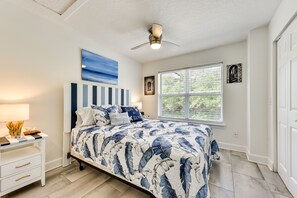 A bedroom with a bed, a nightstand, a ceiling fan, and a window with blinds. - Fernandina Beach Paradise: Steps to Shore! (Fernandina Beach)