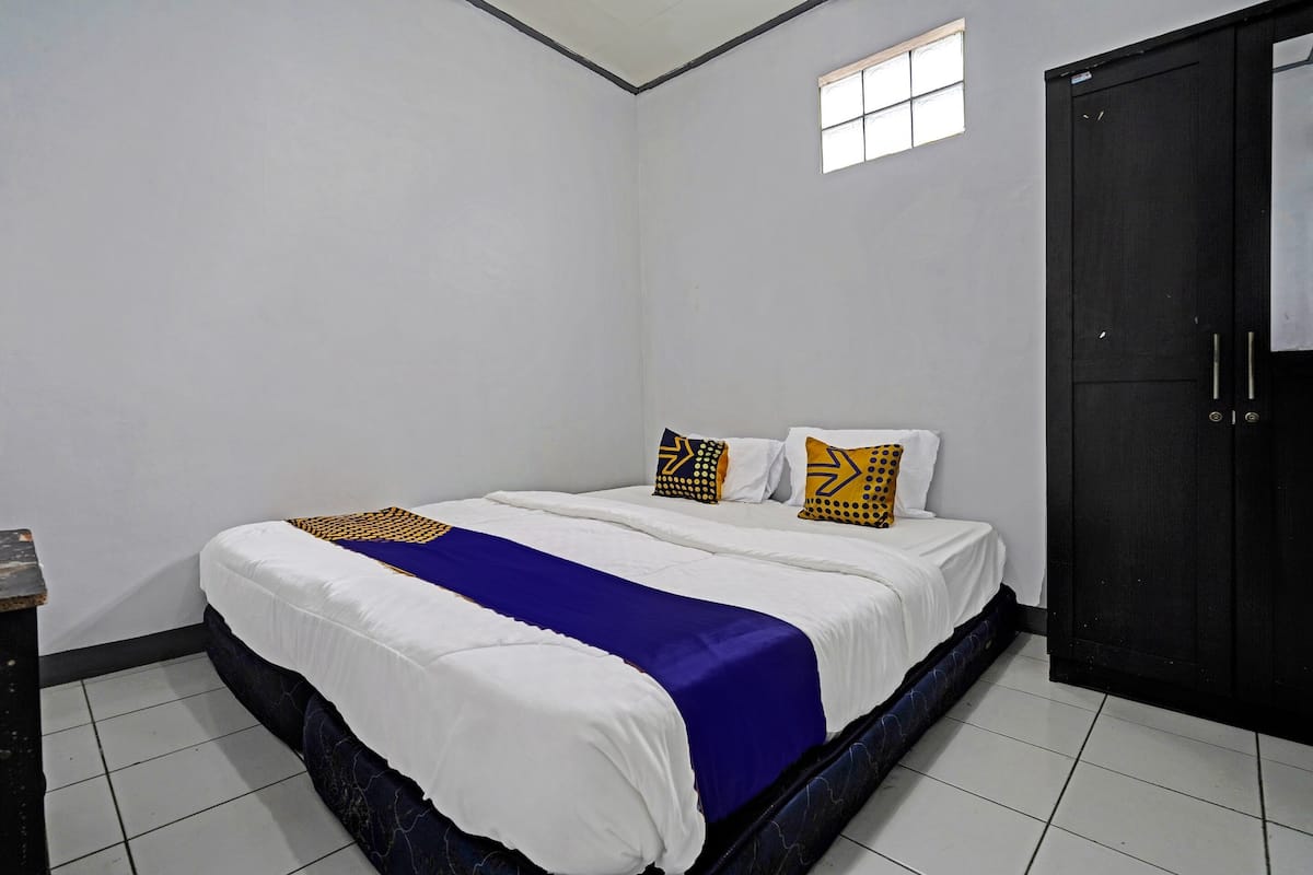 A bedroom with a bed, a window, and a wardrobe.