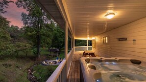 Ein Bereich mit Whirlpool, einer Holzterrasse und Blick auf die umliegende Landschaft.