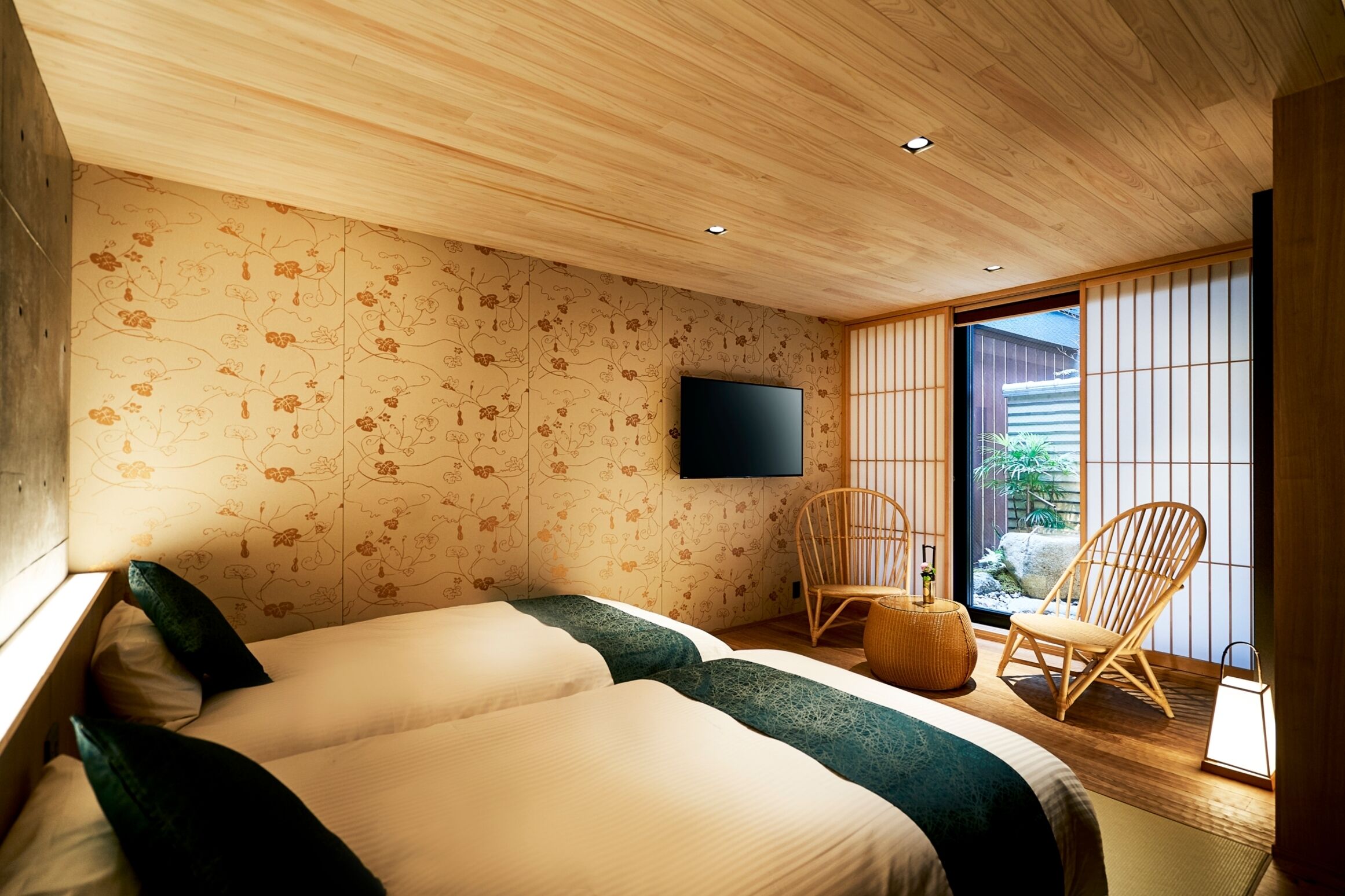 Une chambre moderne dotée d’un grand lit, d’un téléviseur à écran plat et offrant une vue sur l’extérieur grâce à une porte coulissante.
