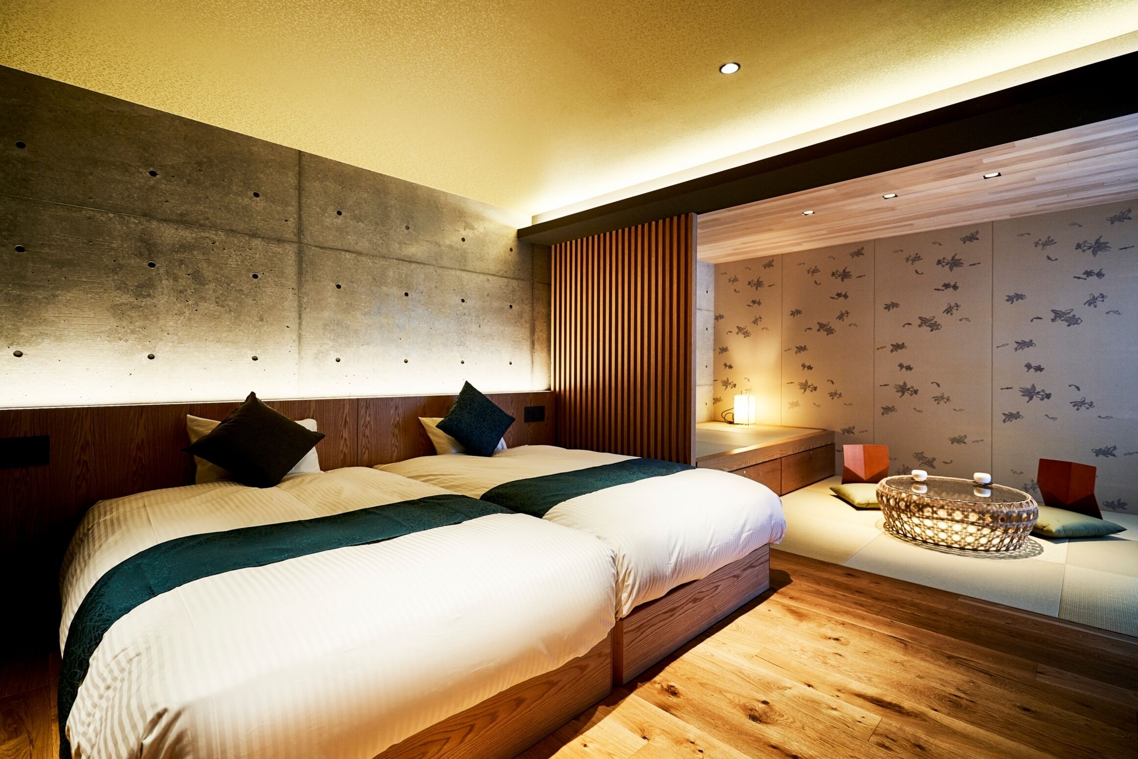 Une chambre d’hôtel moderne avec deux lits, un plancher en bois, une grande fenêtre et un panneau décoratif au mur.