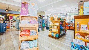 A brightly lit retail store with various clothing items and products on display.