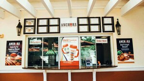 Un restaurante con mostrador, certificados enmarcados y carteles promocionales.