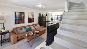 Una sala moderna con sofá, mesa de centro y obras de arte en las paredes.