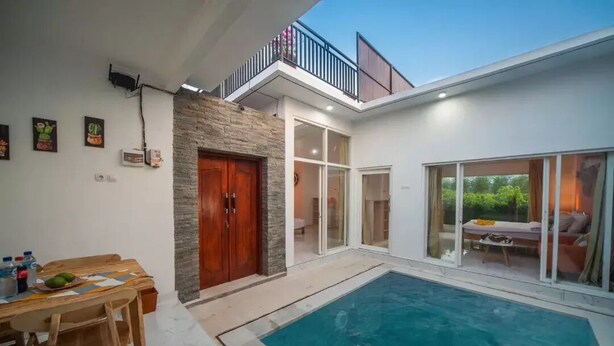 A modern house with a swimming pool, a dining area, and a balcony. - MODERN COZY PRIVATE 2BR VILLA WITH ROOF TOP SUNSET VIEW (Bali)