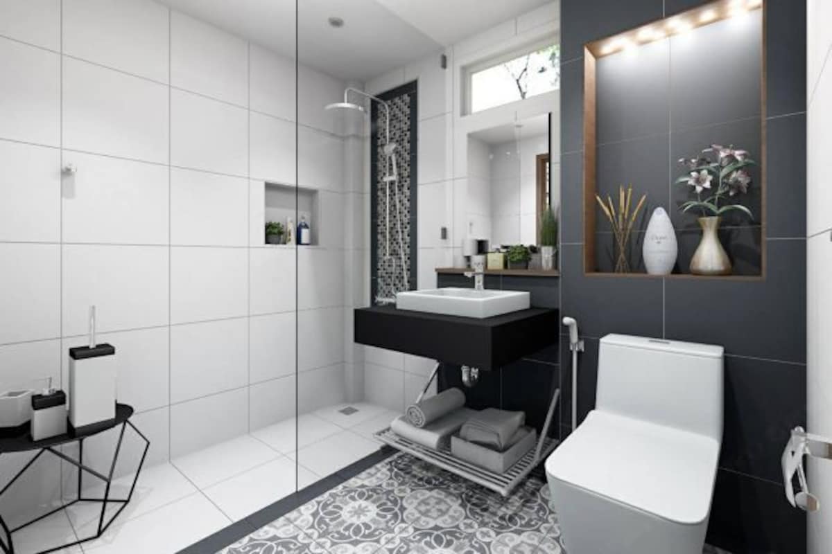 A modern bathroom with a glass shower enclosure, a white toilet, a black vanity with a mirror, and a patterned rug.