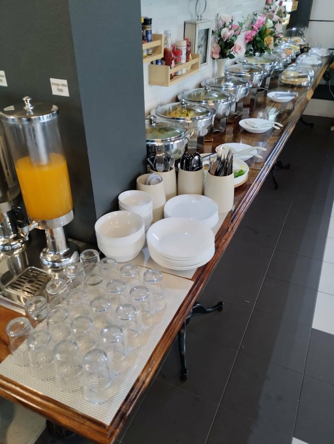A buffet setup with various food containers, bowls, and utensils.