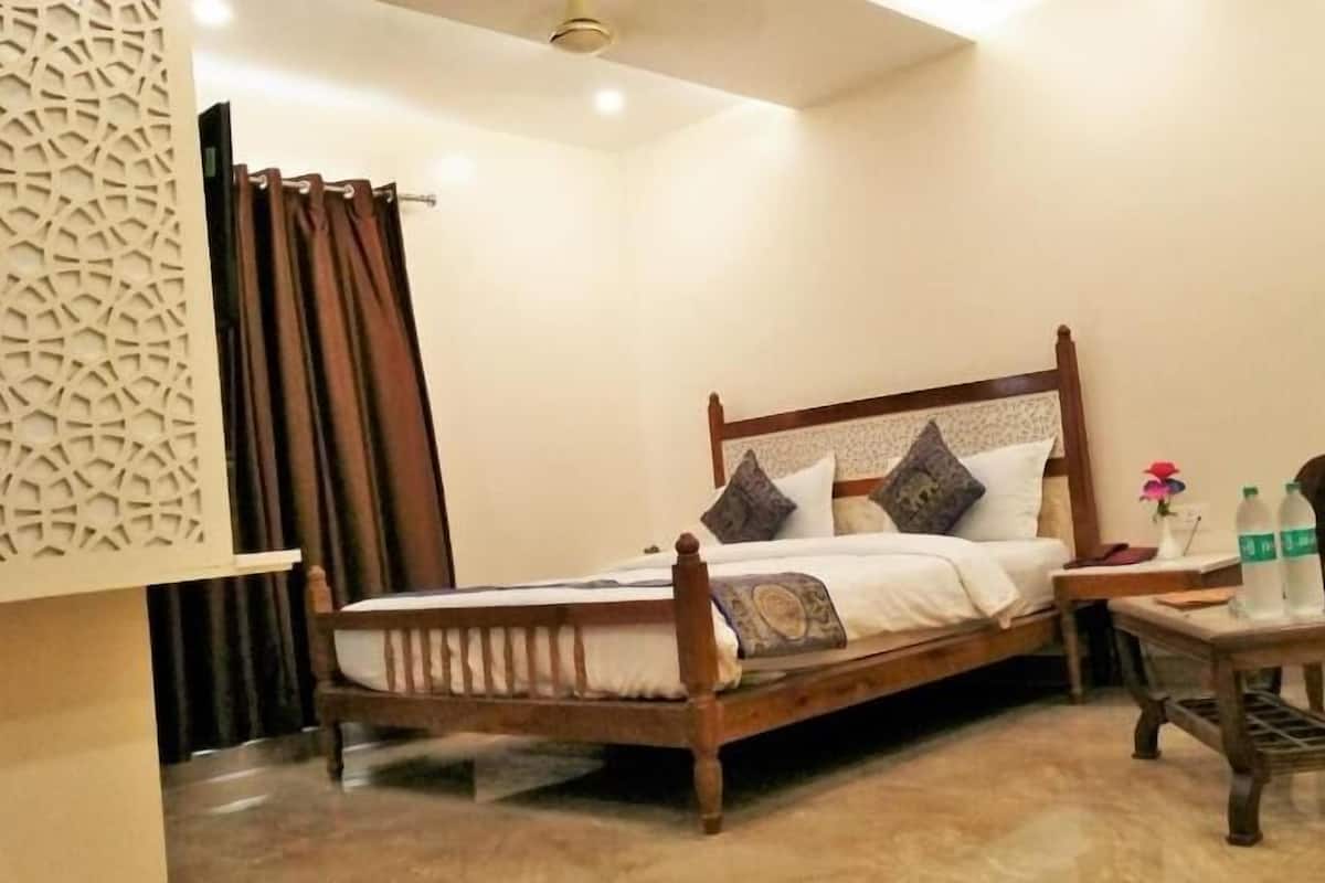 Ein Schlafzimmer mit einem hölzernen Bett, einem Nachttisch, einem Sessel und einer Wandverkleidung.